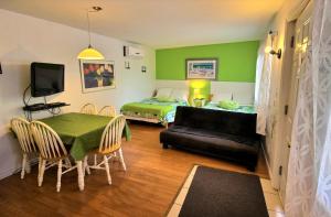 a room with a bed and a table and a couch at Motel des Deux Lacs in Waterloo