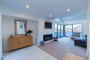 a living room with a fireplace and a couch at Executive Living in Bluewater - 3 Bedroom Apartment in Queenstown