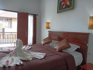 a bedroom with a bed with a robe on it at Dwiki Putra Home Stay in Nusa Lembongan