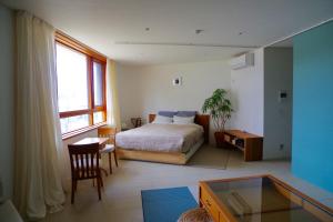藤沢市にあるSango Katase Guest Roomsのベッドルーム1室(ベッド1台、デスク、窓付)