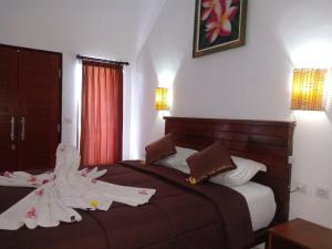 a hotel room with two beds with towels on them at Dwiki Putra Home Stay in Nusa Lembongan