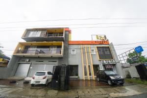 two cars parked in front of a building at Budget Hotel Ambon in Ambon