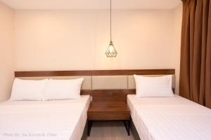 a bedroom with two beds and a light fixture at Griffin Hotel and Suites in Cebu City