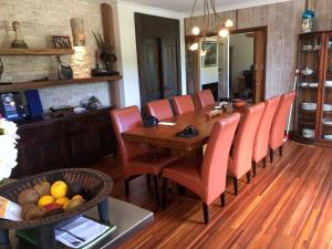 una sala da pranzo con tavolo in legno e sedie arancioni di Bali with a twist a Nelson