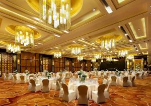 a banquet hall with white tables and chairs and chandeliers at Glenview ITC Plaza Chongqing in Chongqing