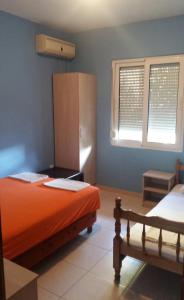 una camera con letto arancione, armadio e finestre di Apartments Nikoleta a Sutomore