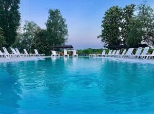 uma grande piscina com cadeiras e água azul em База відпочинку "РіверСайд" em Novomoskovsʼk