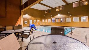 a swimming pool with tables and chairs in a building at Best Western Plus North Las Vegas Inn & Suites in Las Vegas