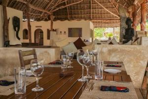 a wooden table with wine glasses on top of it at Zanzibar Pearl - Boutique Hotel & Villas in Matemwe