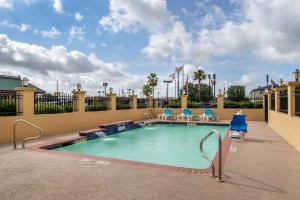 a swimming pool at a resort with blue chairs at Comfort Suites Baytown I – 10 in Baytown