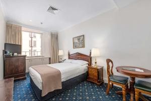 a hotel room with a bed and a desk and a table at Castlereagh Boutique Hotel, an Ascend Collection Hotel in Sydney +59 photos