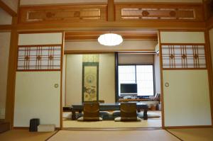 Auberge Fujii Fermier في فوكوي: غرفه فيها بابين وتلفزيون فيها