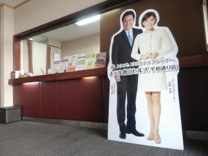 un cartel de un hombre y una mujer en un cartel en Hotel Tokuyama Hills Heiwadoriten, en Shunan