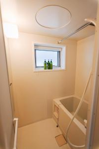 a bathroom with a bath tub and a window at Trailside Apartments Niseko in Kutchan +31 photos