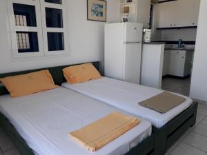 um quarto com 2 camas numa cozinha com um frigorífico em Vivlos. Maisonette with View em Vívlos