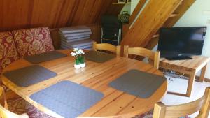 a dining room table with a television and a wooden table at Ferienhaus Nr. 40 im Ferienpark am Twistesee in Bad Arolsen