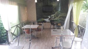un restaurante con mesas y sillas en un balcón en AdlerOk Guest House, en Adler