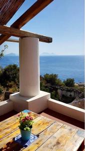 a porch with a table and a view of the ocean at Luna Rossa in Ginostra