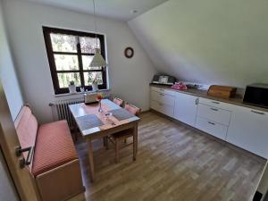 een keuken met een tafel en stoelen en een raam bij Kucks-Ferienwohnung in Wiefelstede