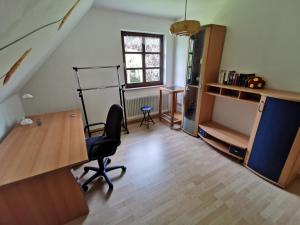 een kantoor met een bureau en een stoel in een kamer bij Kucks-Ferienwohnung in Wiefelstede