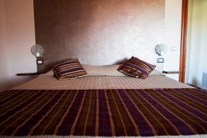 a bedroom with a large bed with two pillows at Tenuta San Savino delle Rocchette in Poggiolo
