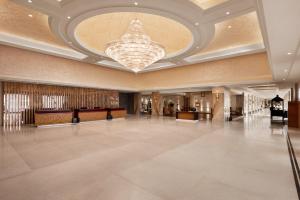 eine große Lobby mit einem Kronleuchter an der Decke in der Unterkunft Ramada Plaza by Wyndham Lucknow in Lucknow