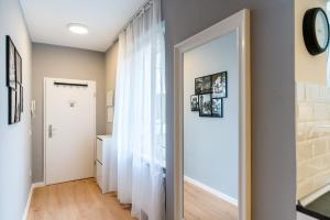 a hallway with a door and a clock on a wall at Centerapartments Marienstrasse in Düsseldorf +36 photos