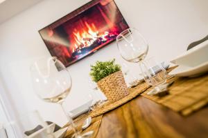 a table with three wine glasses and a fireplace at Centerapartments Marienstrasse in Düsseldorf