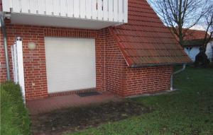 a red brick house with a white garage door at Nice Apartment In Insel Poel-gollwitz With 1 Bedrooms in Gollwitz
