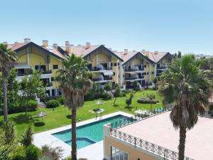 una vista aérea de un complejo con piscina y palmeras en Prime Apartment Beloura, en Sintra