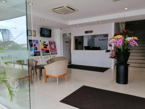 una hall con tavolo, sedie e fiori di Northern Lodge Hotel a Sungai Petani