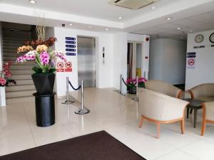 a lobby with chairs and a vase of flowers at Northern Lodge Hotel in Sungai Petani