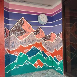 a mural of mountains on a wall with a moon at Dormitels.ph España Manila in Manila