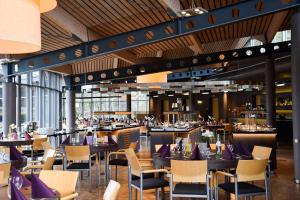 a restaurant with tables and chairs with purple seats at Hotel Park Soltau in Soltau