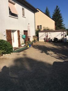 un patio trasero de una casa con una valla y una sombrilla en CHAMBRE INDEPENDANTE + SANITAIRE près centre ville en Rignac