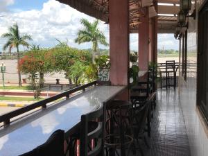a bar with a view of the beach and palm trees at Mekong Crossing Guesthouse - Restaurant & Pub in Kampong Cham
