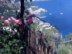 アマルフィにあるVilla Matilde Amalfiの花の柵から見えるアマルフィ海岸