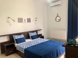 a bedroom with a blue bed with blue pillows at Casa Lotca in Costinesti