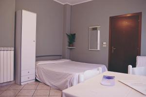 a small room with two beds and a mirror at Residence Perla in Alassio