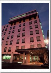 泉佐野市にある関空ホテル サンプラスユタカの大きなピンクの建物