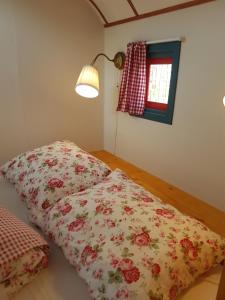 1 dormitorio con 2 almohadas en el suelo y lámpara en Gezellig pipowagen in Oostvoorne, en Oostvoorne