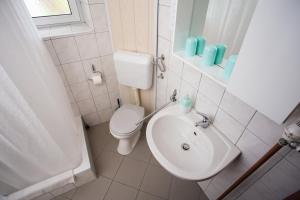 bagno bianco con servizi igienici e lavandino di Guest House ANA.k a Postumia