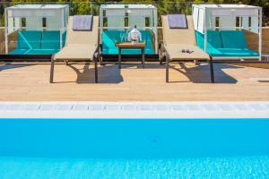 um grupo de cadeiras sentadas ao lado de uma piscina em Golden Costa Salou - Adults Only 4* Sup em Salou