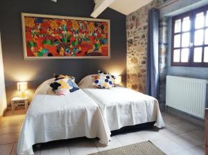 ブイスにあるDomaine des Goudisのベッドルーム1室(ベッド2台付)が備わります。壁には絵画が飾られています。