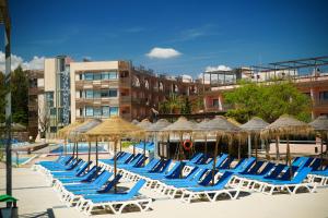 a row of lounge chairs and umbrellas on a beach at Ohtels Les Oliveres in Perelló