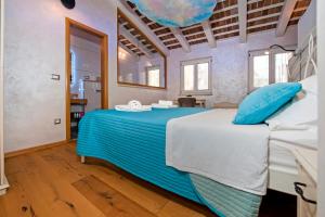 ein Schlafzimmer mit einem Bett mit blauen Kissen darauf in der Unterkunft Nuvola in Rovinj