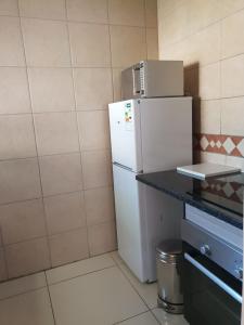 uma cozinha com um frigorífico branco e um balcão em LANGA 'S COZY GUESTHOUSE em Pretoria