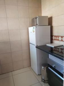 a kitchen with a white refrigerator and a counter at LANGA 'S COZY GUESTHOUSE in Pretoria