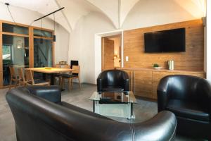 salon z 2 skórzanymi krzesłami i telewizorem w obiekcie Nowders Apartments w mieście Nauders