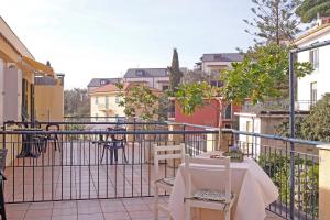 patio con mesa y sillas en el balcón en Residence Perla, en Alassio